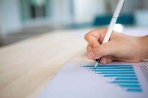 Accountants working on graphs with a pen